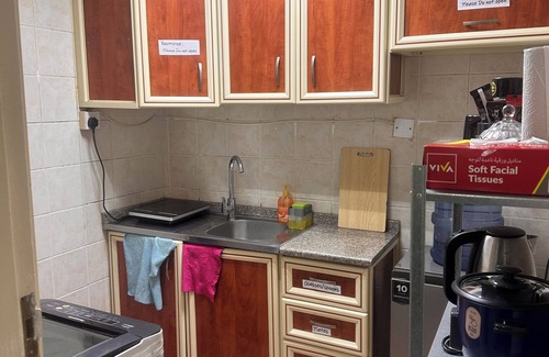 Al Zahiyah Apartment | a charming and cozy purple themed room within the heart of the city .