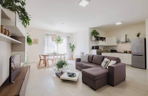 Ta' Pennellu Apartment | Bright and stylish 2-bedroom apartment in the heart of Mellieha, Malta. Located in a quiet residential area, it features a charming louvered balcony, large sunlit windows, and modern interiors with natural touches