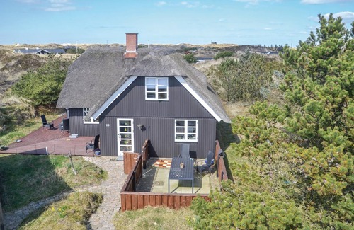 Grærup Strand House | Cozy cottage with thatched roof and situated on an uneven dune plot in Grærup Strand.
