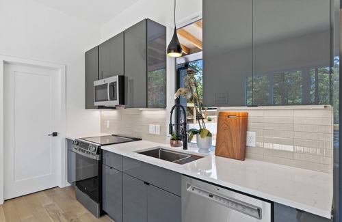 Young Harris Apartment | Enjoy treetop views in a 2BR/1BA tiny home nestled in the North Georgia mountains. Whip up meals in the chef’s kitchen, cozy up by the wood-burning stove, unplug in the spa-style shower, relax on your private deck, and cool off in the community pool.