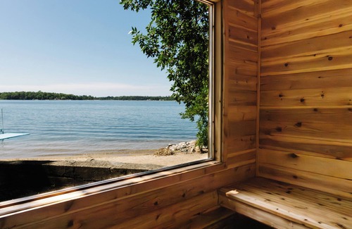 Nevis House | Luxury Lake Belle Taine retreat with private beach, sauna & four-season fun.