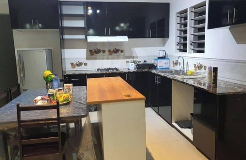 Suva Apartment | Master Bedroom with shared kitchen and living room