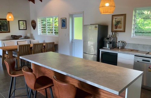 Takitumu District House | Modern holiday home. 1 minute walk to tropical beach, cafe and turtle swim.
