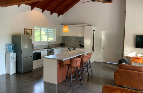 Takitumu District House | Modern holiday home. 1 minute walk to tropical beach, cafe and turtle swim.