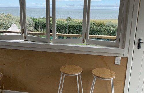 Cape Palliser House | Ocean views of the Kaikoura's and surf break. Private beach hut.