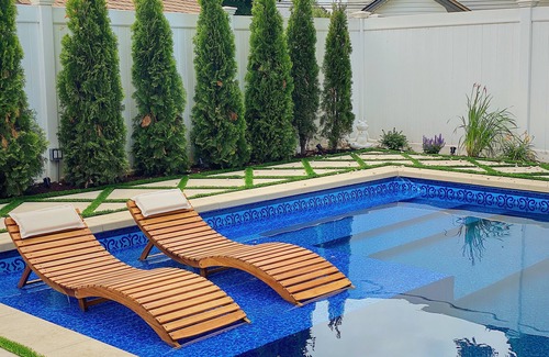 Baldwin Harbor Apartment | Poolside play with a relaxing hot tub, fire pit, & gazebo with a television.