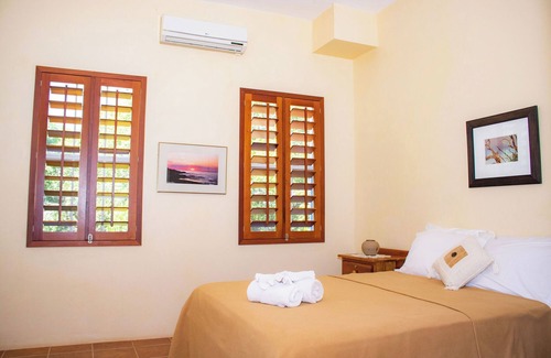 Orchid Bay Bed & Breakfast | Queen-size bed, with a private bathroom, a walk-in shower and closet.