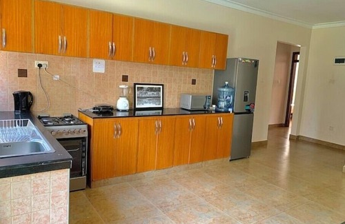 Kampala House | Quiet and peaceful hidden gem surrounded by lush greenery and vibrant flowers.n