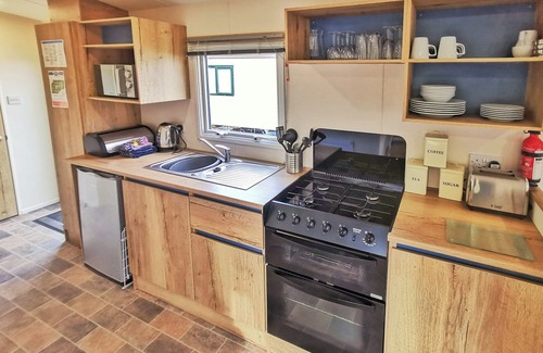 Llanllwchaiarn House | Spacious and well-presented 12ft-wide caravan with one double and two twin bedrooms.