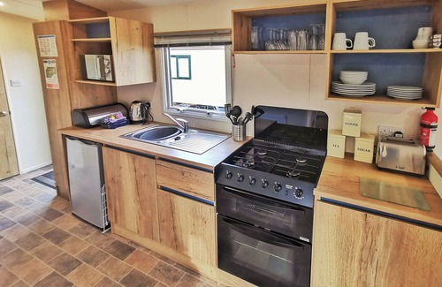 Llanllwchaiarn House | Spacious and well presented, 12-ft wide caravan with one double and one twin bedroom.