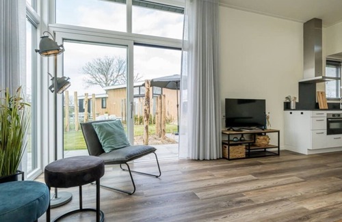 Burgh-Haamstede House | Spacious living room with a stylish interior, charming accents and a beautiful view of the expansive