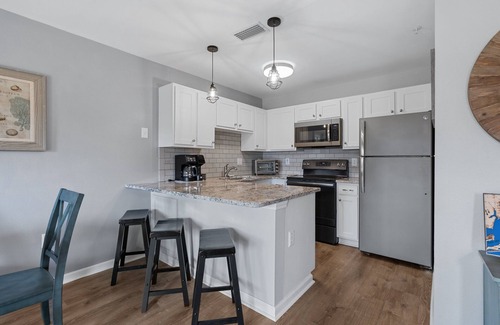 Ono Island Condo | Steps to Pools, Hot Tub, Beach | Poolside Palms | Garden Level Patio & Lawn Area