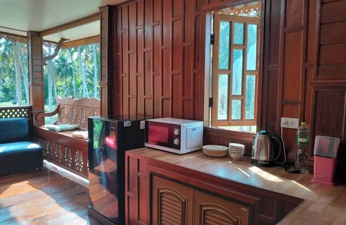Thong Chai House | Traditional Thai wooden house on stilts set in a coconut orchard near the beach