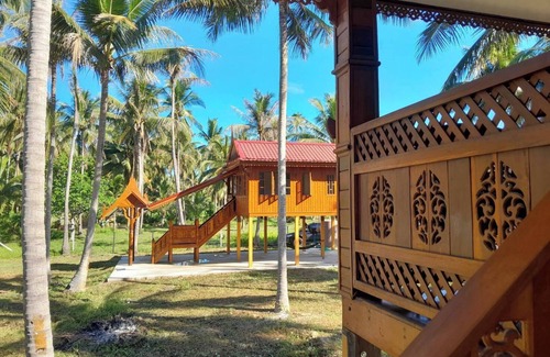 Thong Chai House | Traditional Thai wooden house on stilts set in a coconut orchard near the beach