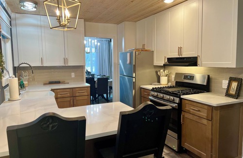 Howell House | Tranquil haven with a roomy deck and stunning panoramic lake views.
