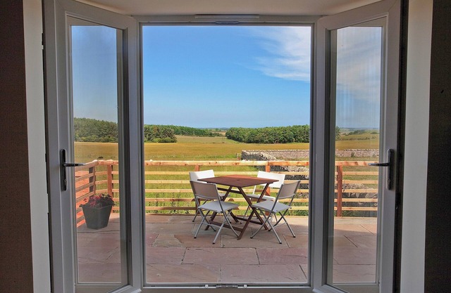 A stylish cottage with rural views towards the coastline from the patio.