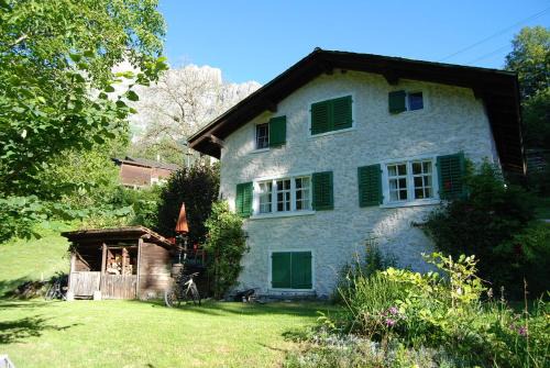 Bergbauernhaus an Wasserfall und Waldrand