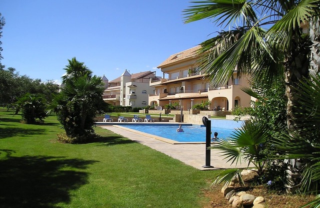 Modern duplex house overlooking communal pool and gardens at Golf Panoramica.
