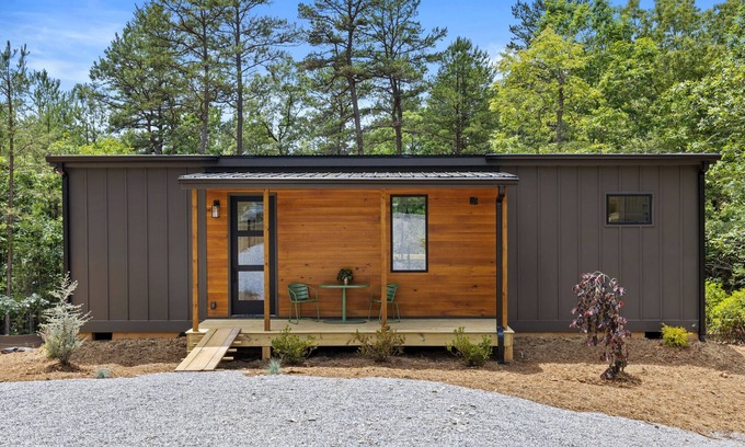Young Harris Apartment | Enjoy treetop views in a 2BR/1BA tiny home nestled in the North Georgia mountains. Whip up meals in the chef’s kitchen, cozy up by the wood-burning stove, unplug in the spa-style shower, relax on your private deck, and cool off in the community pool.