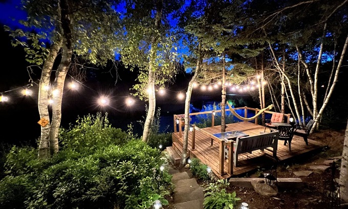 Cap-Pele Ski Chalet | Luxurious rustic wooden chalet on edge of tranquil pond in nature next to beach.