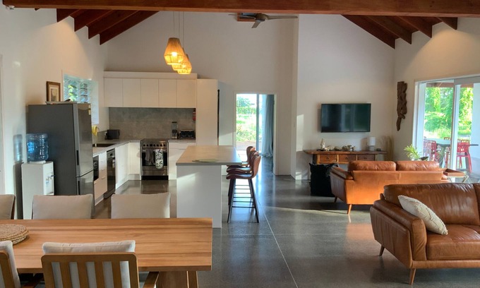Takitumu District House | Modern holiday home. 1 minute walk to tropical beach, cafe and turtle swim.