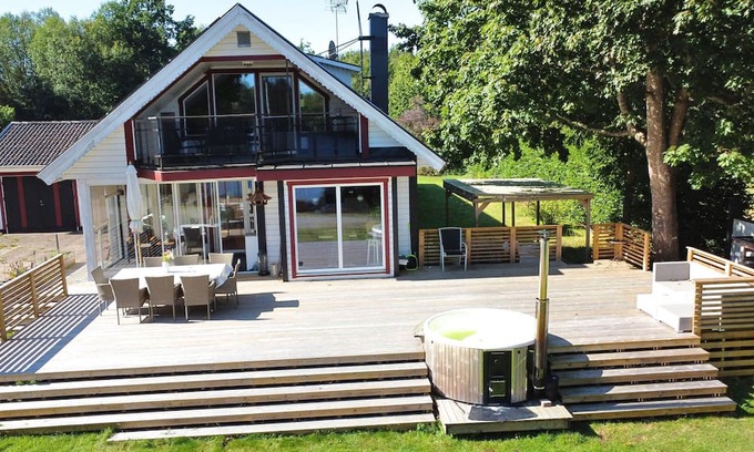 Vissefjaerda House | Vacation home right on the lake in Småland - Villa lake view with hot tub, boat & canoe